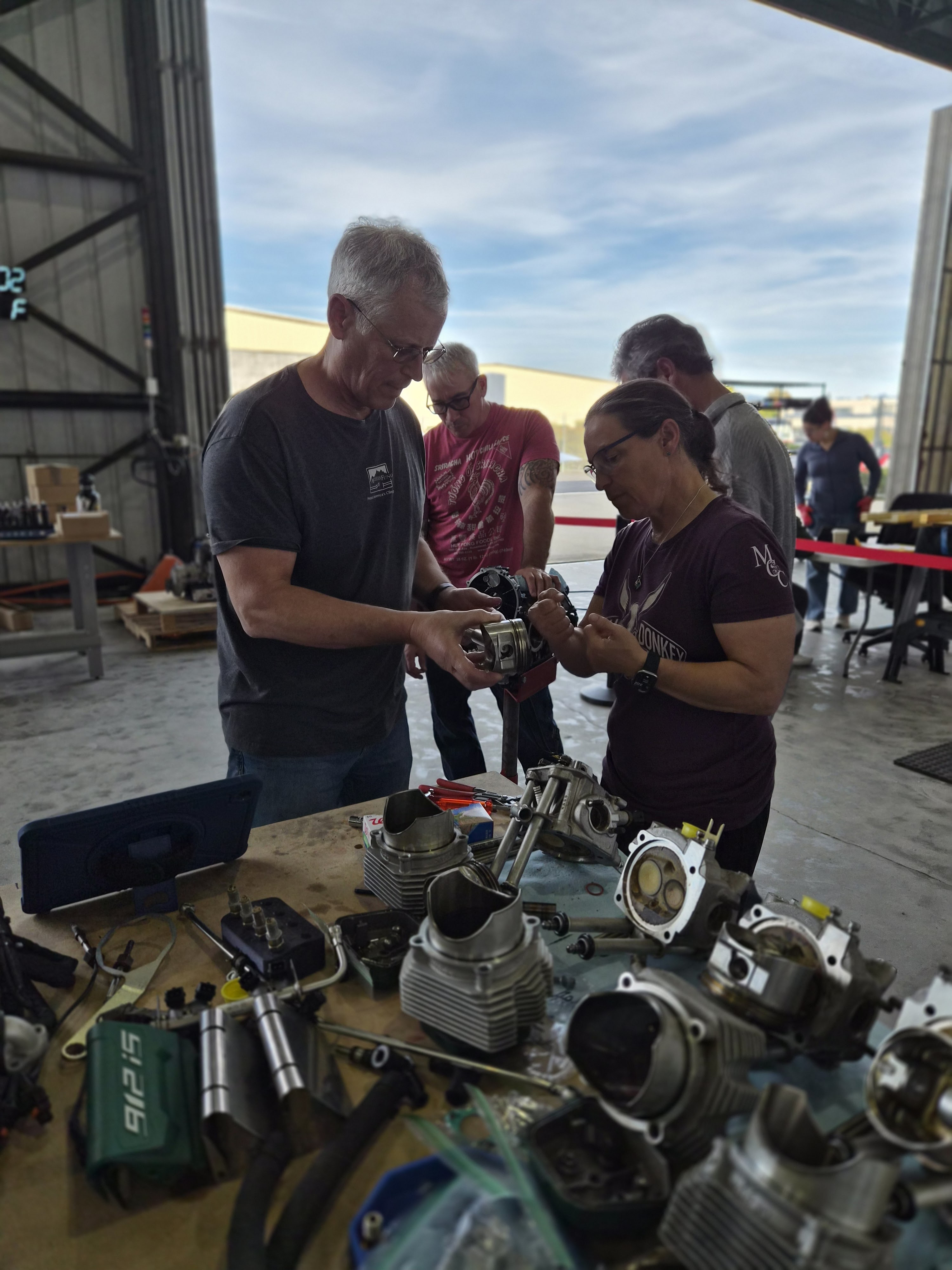 Instructor and students examining Rotax engine cylinders